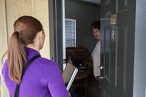 An APS caseworker knocks on a clients door 