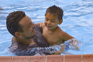A father and son playing in the pool