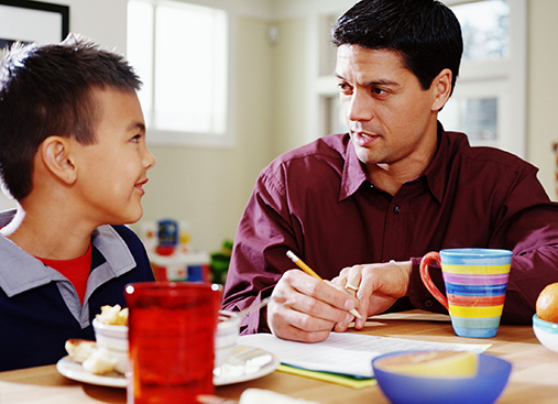 Male adult helping a child with homework